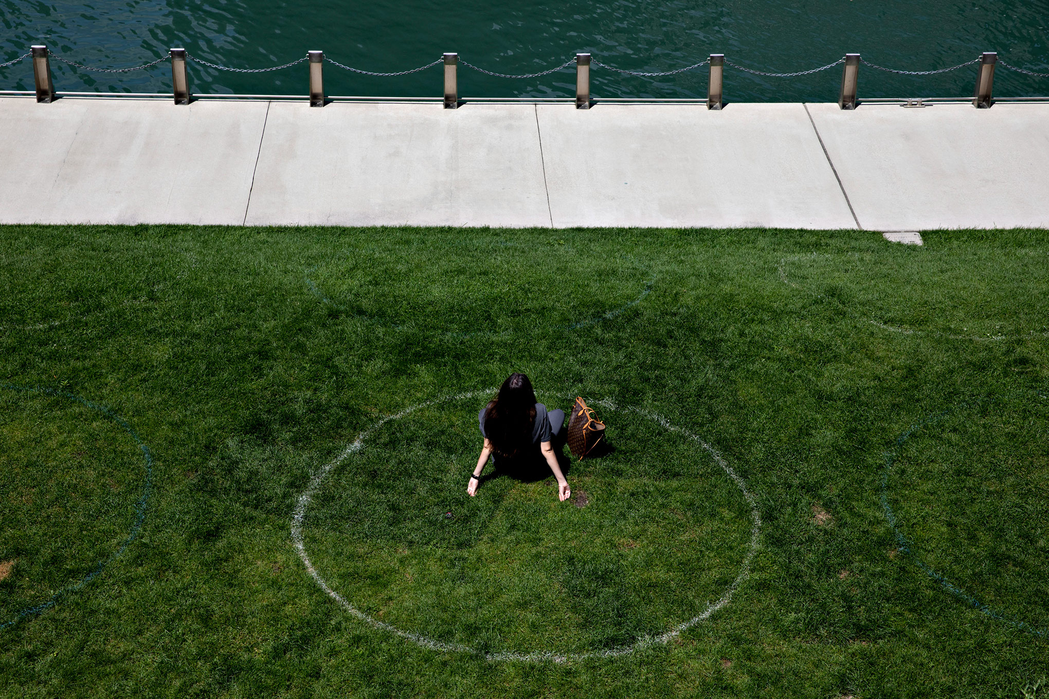A woman sits in a social distance circle along the Chicago River in Chicago, on Aug. 4, 2020.